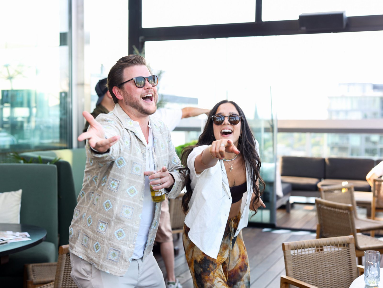 Man and woman having fun at a party captured by Ineffable Views roaming photographer for your social events, brand launches, and more, who captures stunning images with a branded overlay